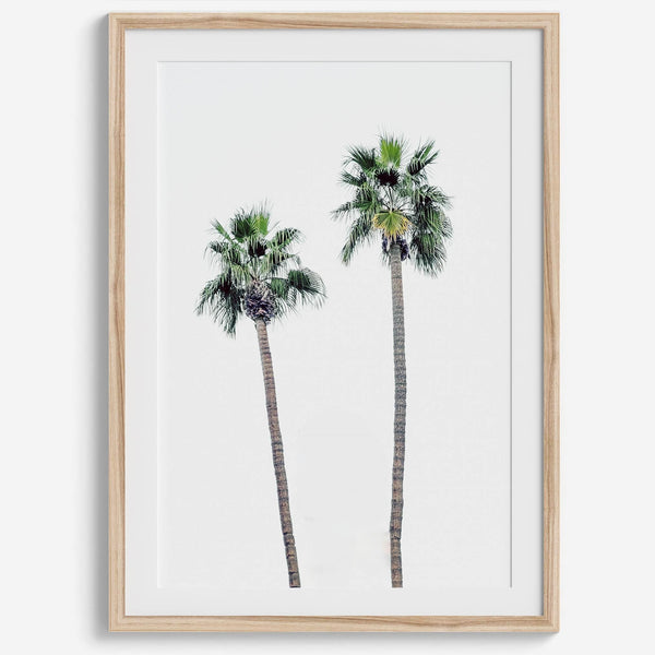 Minimalist fine art beach photography print of two tall palm trees against a white sky. Coastal decor.