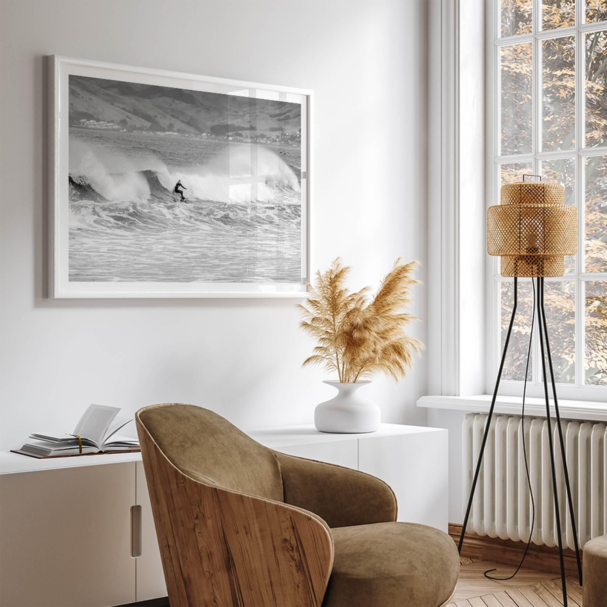 A black and white fine art surf print featuring a lone surfer riding the waves in Pismo Beach, California.