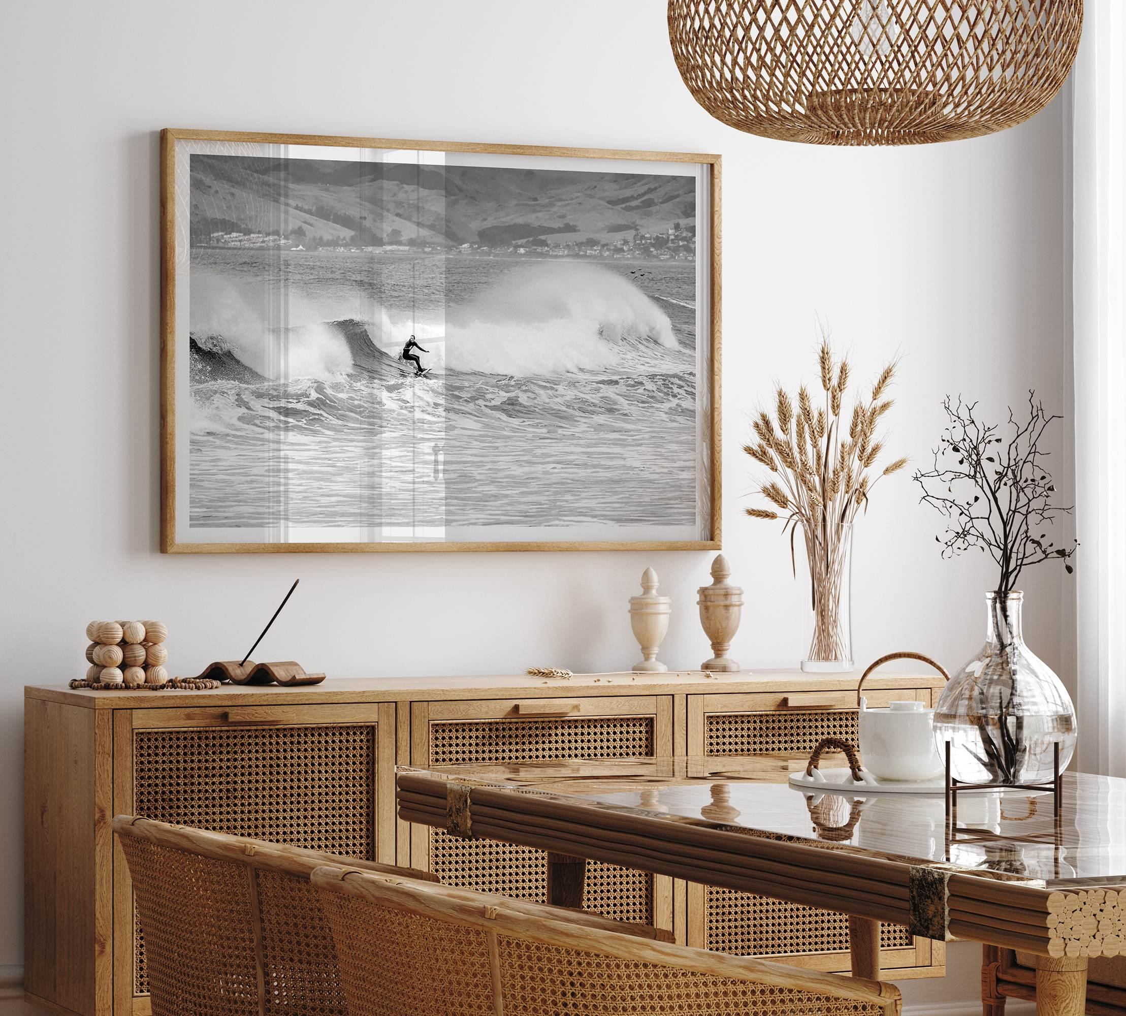 A black and white fine art surf print featuring a lone surfer riding the waves in Pismo Beach, California.