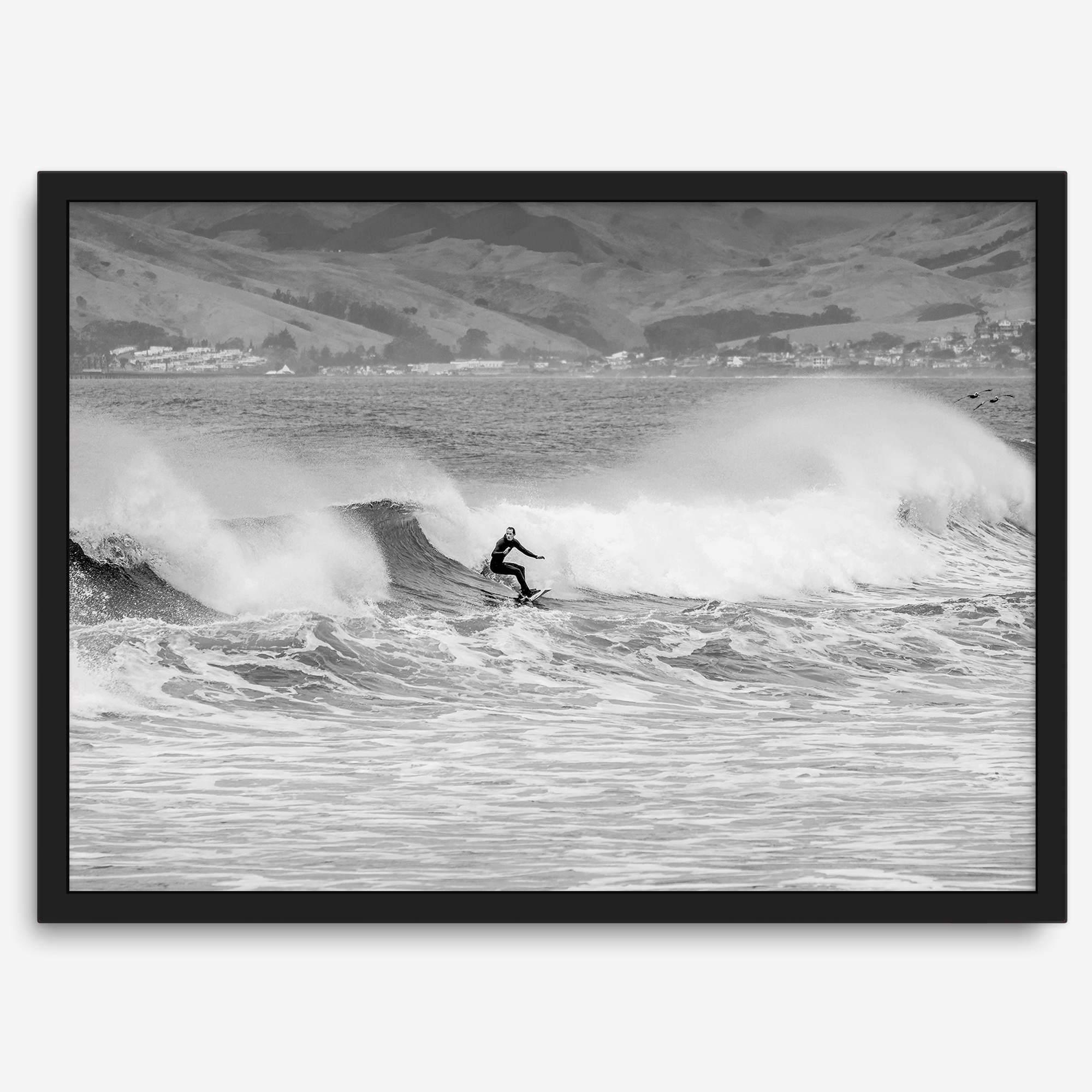 A black and white fine art surf print featuring a lone surfer riding the waves in Pismo Beach, California.