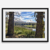 Fisherman at Manzanita Lake beneath snowy mountains and pine forest, photographed as peaceful fishing wall art.