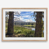 Fisherman at Manzanita Lake beneath snowy mountains and pine forest, photographed as peaceful fishing wall art.