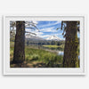 Fisherman at Manzanita Lake beneath snowy mountains and pine forest, photographed as peaceful fishing wall art.