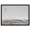 Wind surfer riding waves in Maui with kite above and misty ocean below.