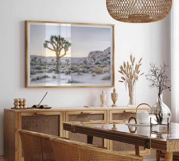 A fine art California desert print showcasing a lone Joshua Tree in the sunset with desert plantation and rocks.