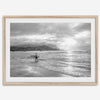 Surfer Wall Art featuring a lone surfer emerging from the ocean at Hanalei Bay in black-and-white photography.