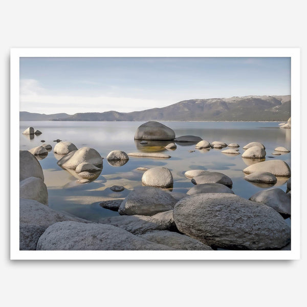This breathtaking fine art Lake Tahoe print captures the perfect shape of the huge rocks that rise from the crystal-clear water, creating a beautiful contrast against the blue sky and the distant mountain range.