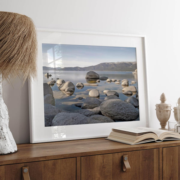 This breathtaking fine art Lake Tahoe print captures the perfect shape of the huge rocks that rise from the crystal-clear water, creating a beautiful contrast against the blue sky and the distant mountain range.