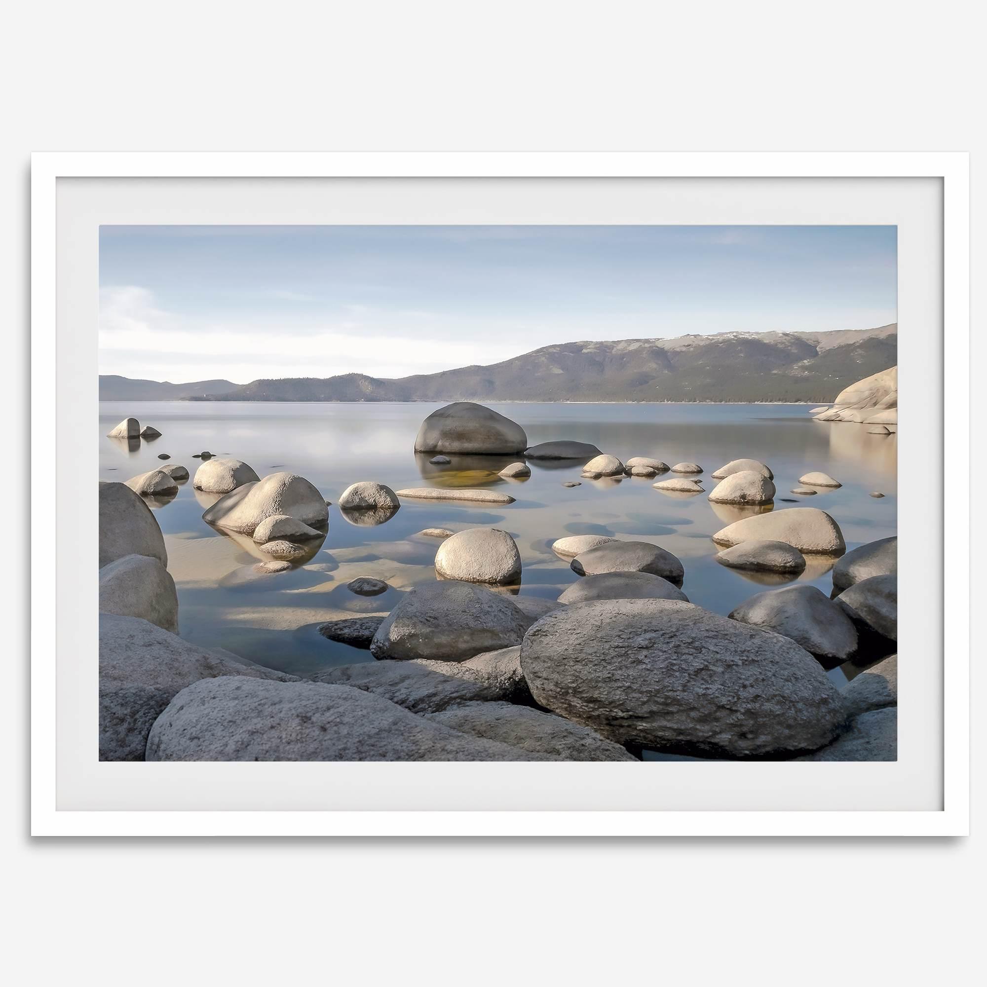 This breathtaking fine art Lake Tahoe print captures the perfect shape of the huge rocks that rise from the crystal-clear water, creating a beautiful contrast against the blue sky and the distant mountain range.