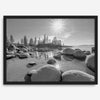 Capture the beauty of Lake Tahoe with this stunning black and white lake wall art. The image showcases majestic rocks rising from crystal-clear water. The reflection of the sun in the water adds a magical touch to the breathtaking scenery.