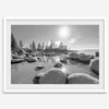 Capture the beauty of Lake Tahoe with this stunning black and white lake wall art. The image showcases majestic rocks rising from crystal-clear water. The reflection of the sun in the water adds a magical touch to the breathtaking scenery.