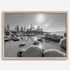 Capture the beauty of Lake Tahoe with this stunning black and white lake wall art. The image showcases majestic rocks rising from crystal-clear water. The reflection of the sun in the water adds a magical touch to the breathtaking scenery.