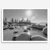 Capture the beauty of Lake Tahoe with this stunning black and white lake wall art. The image showcases majestic rocks rising from crystal-clear water. The reflection of the sun in the water adds a magical touch to the breathtaking scenery.