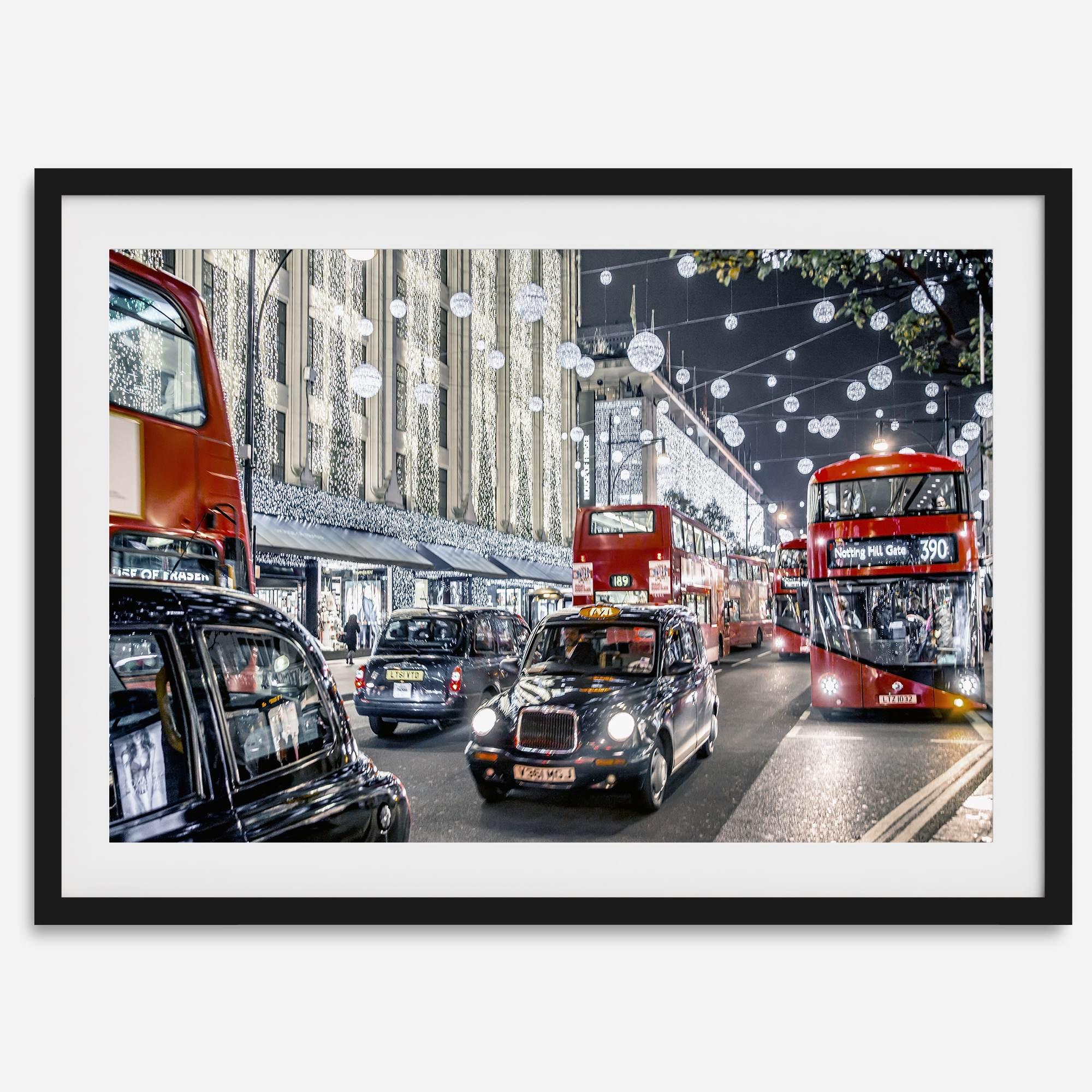 Fine art photography print of a bustling London street during Christmas, featuring double-decker buses, black taxis, and festive holiday lights.