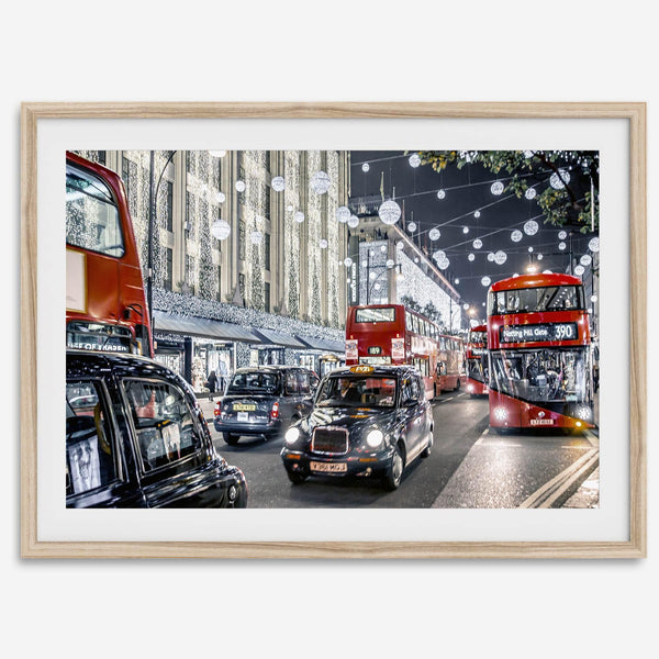 Fine art photography print of a bustling London street during Christmas, featuring double-decker buses, black taxis, and festive holiday lights.