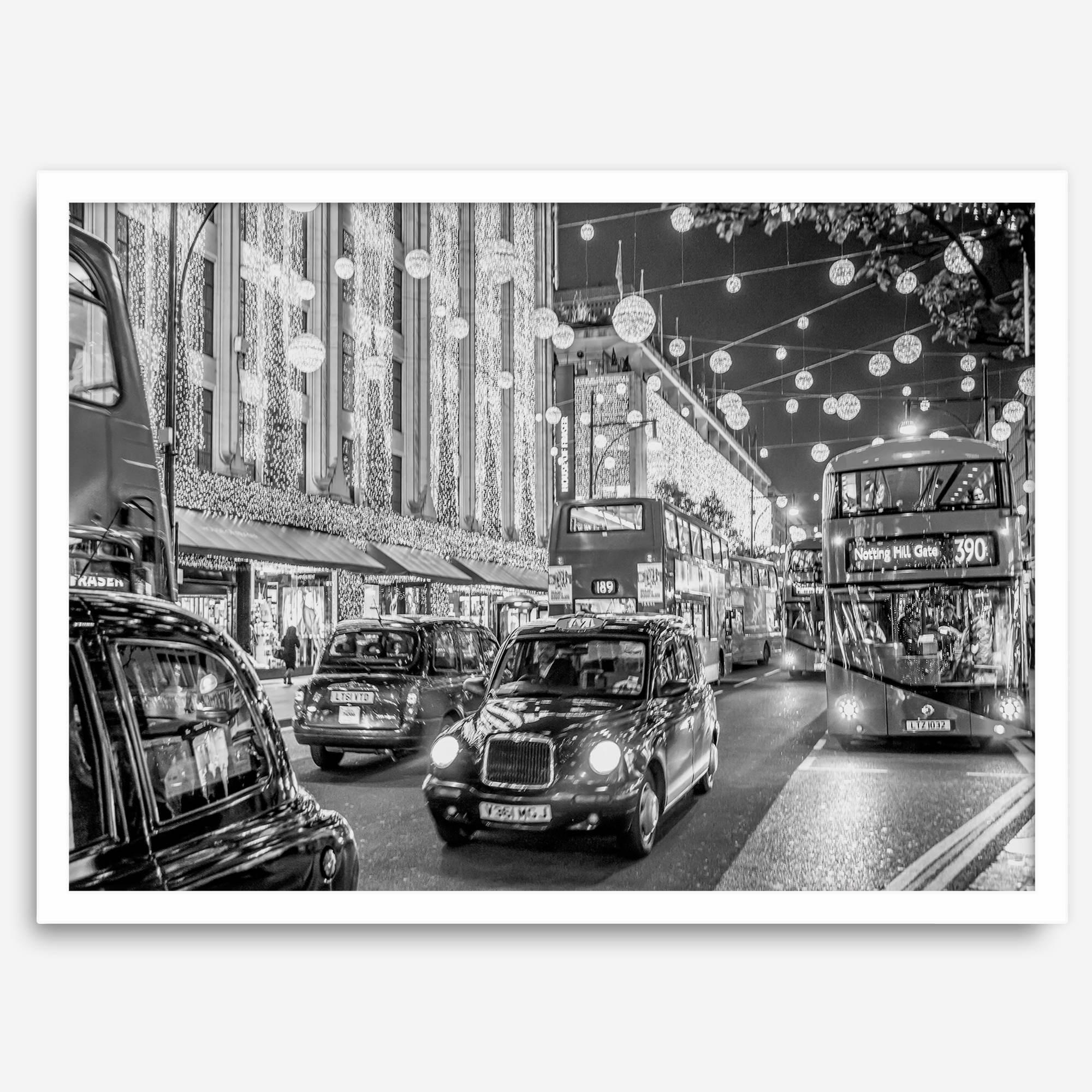 Black and white fine art photography print of a lively London street during Christmas, featuring double-decker buses, black taxis, and festive holiday lights.
