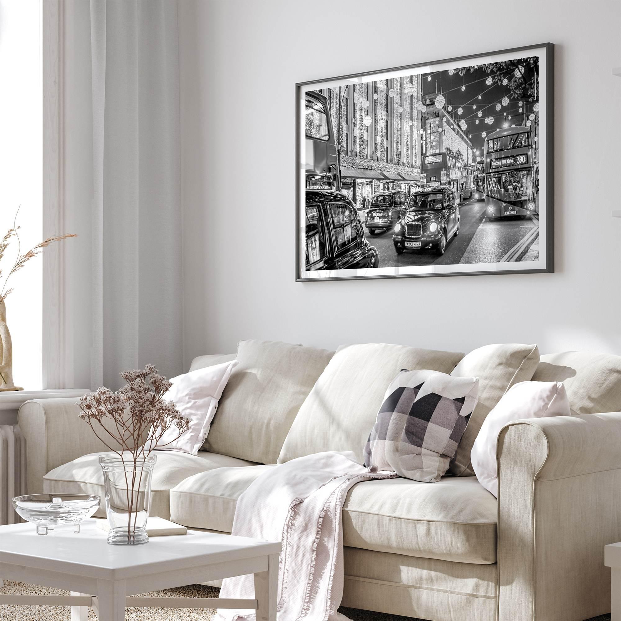 Black and white fine art photography print of a lively London street during Christmas, featuring double-decker buses, black taxis, and festive holiday lights.