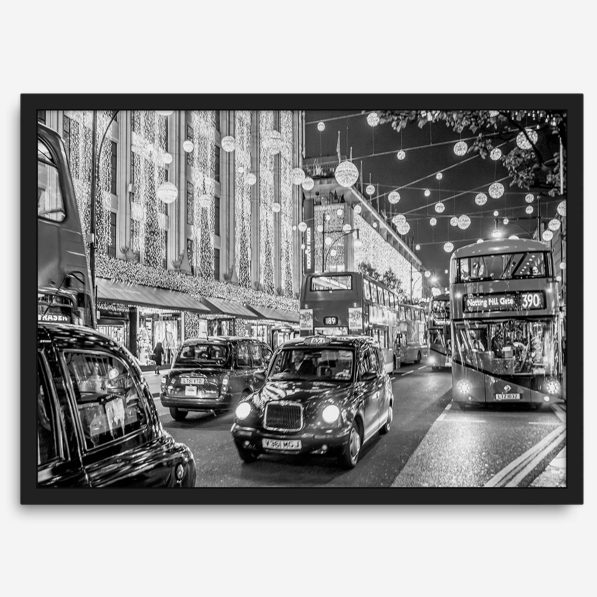 Black and white fine art photography print of a lively London street during Christmas, featuring double-decker buses, black taxis, and festive holiday lights.