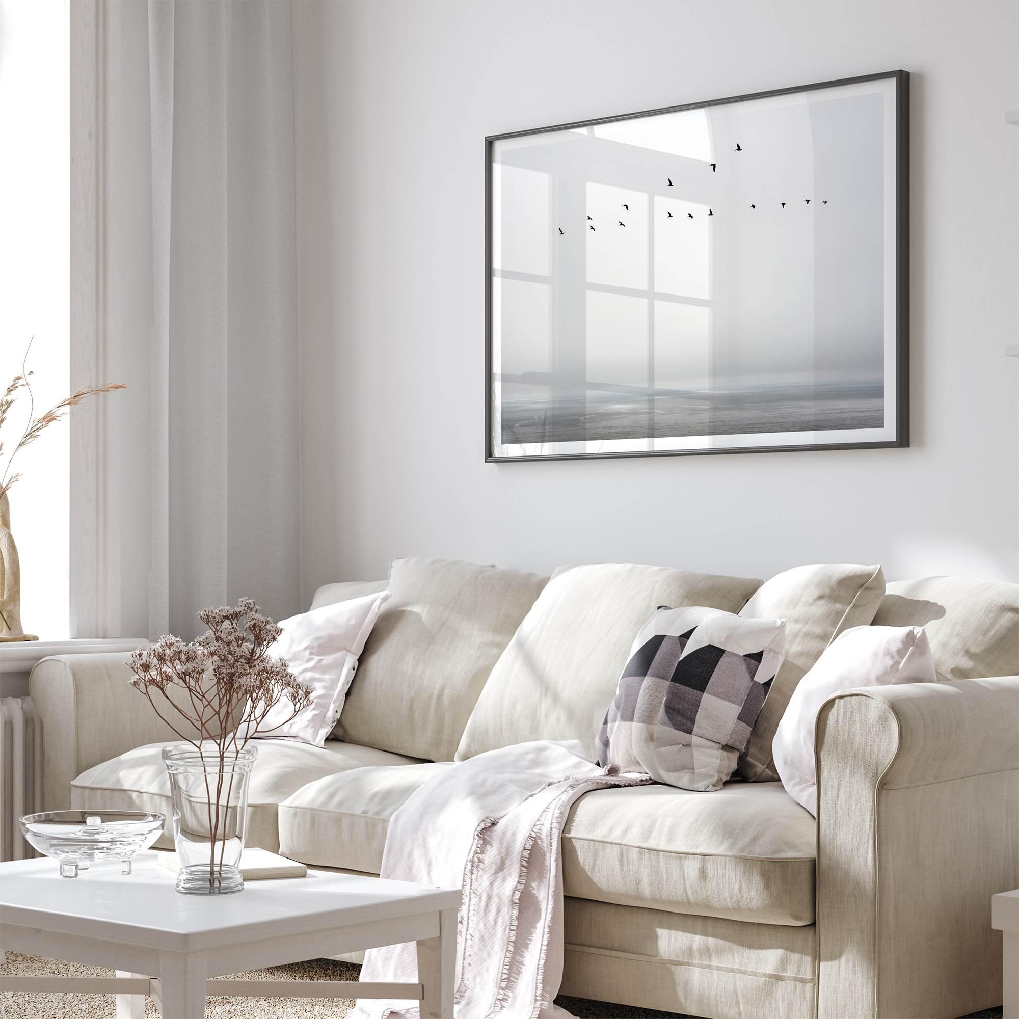 Minimalist seascape fine art print – a flock of birds in flight over a calm, misty ocean with a soft, gray horizon.