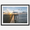 A fine art ocean sunset print featuring Pismo Beach Pier in Sunset with the surfers in the ocean and people enjoying a stroll on the pier.