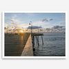 A fine art ocean sunset print featuring Pismo Beach Pier in Sunset with the surfers in the ocean and people enjoying a stroll on the pier.