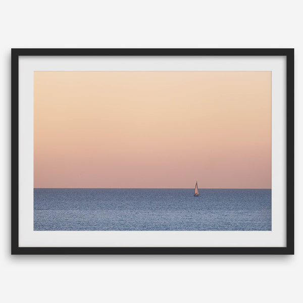 This stunning fine art ocean sunset photography print features a breathtaking scene of a boat against a golden and pink sky at sunset. The warm glow of the sunset and the natural beauty of the ocean and sky combine to create a soothing atmosphere.