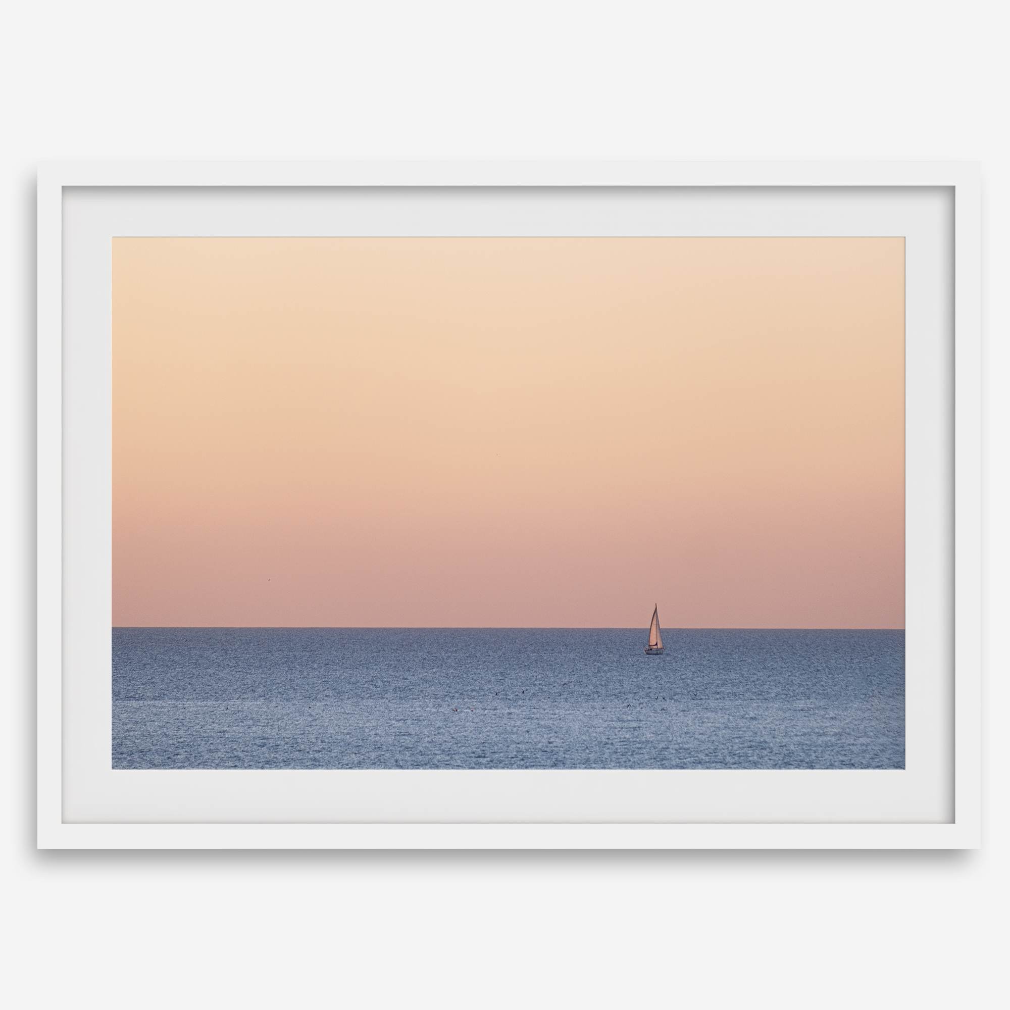 This stunning fine art ocean sunset photography print features a breathtaking scene of a boat against a golden and pink sky at sunset. The warm glow of the sunset and the natural beauty of the ocean and sky combine to create a soothing atmosphere.