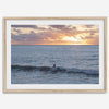 A fine art ocean sunset print showcasing a serene sunset and a lone surfer riding the waves. Taken in Montana De Oro State Park, California.