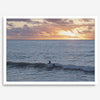 A fine art ocean sunset print showcasing a serene sunset and a lone surfer riding the waves. Taken in Montana De Oro State Park, California.