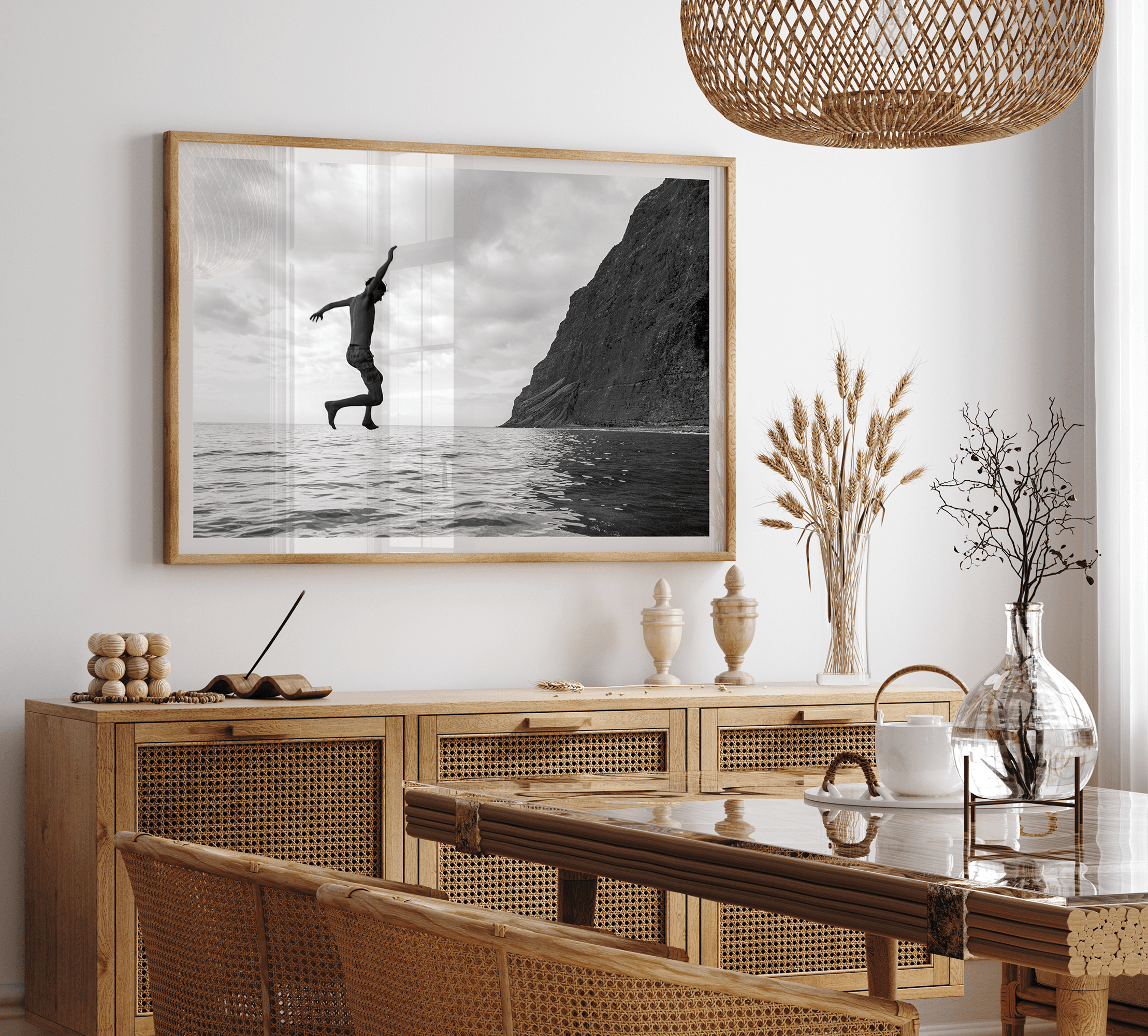 Black and white fine art print of a man mid-jump into the ocean near the cliffs of Na Pali Coast, Kauai.