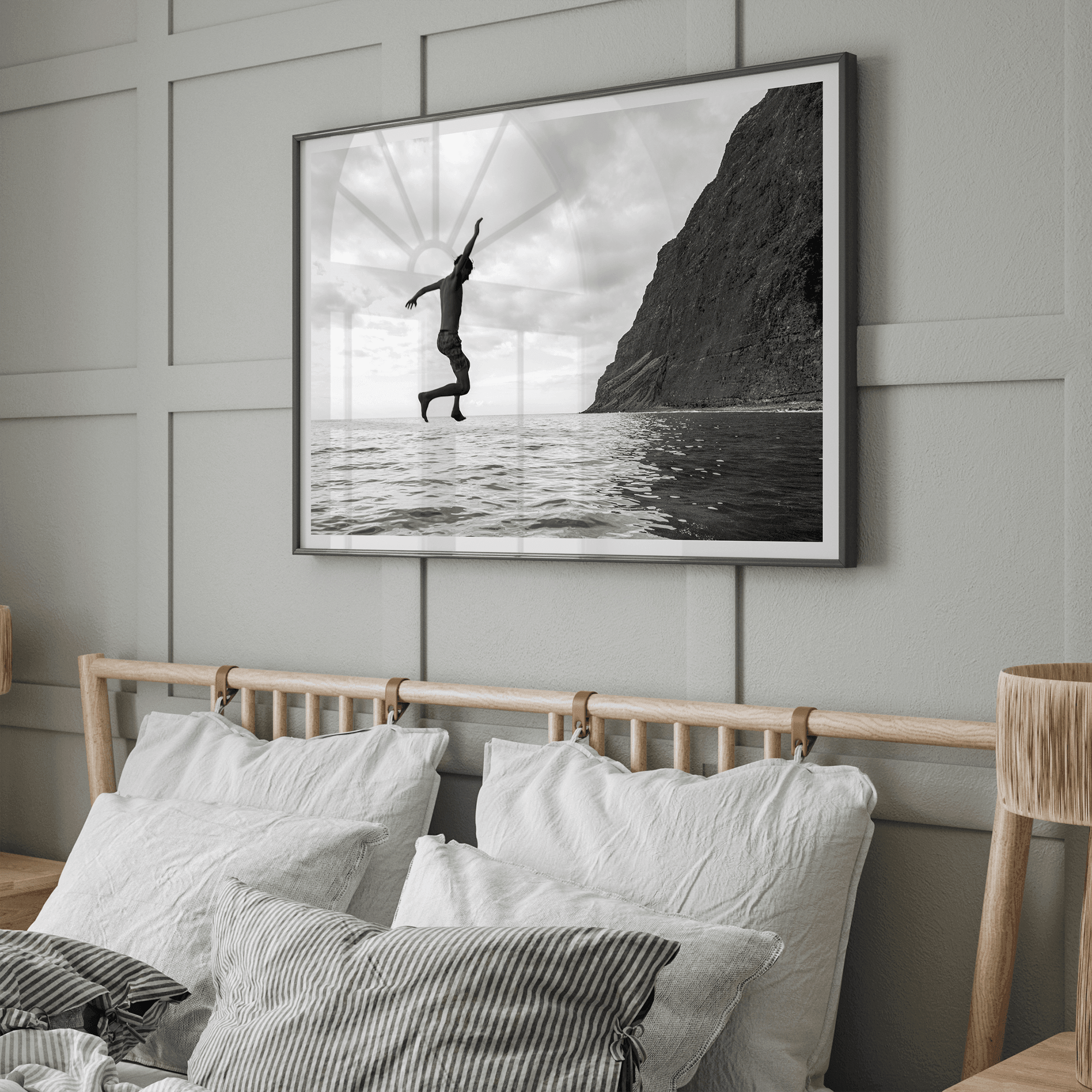 Black and white fine art print of a man mid-jump into the ocean near the cliffs of Na Pali Coast, Kauai.