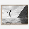 Black and white fine art print of a man mid-jump into the ocean near the cliffs of Na Pali Coast, Kauai.