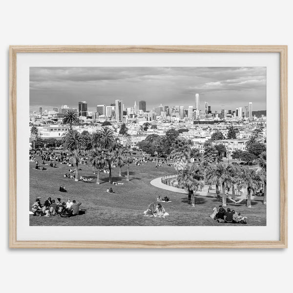 Black and white fine art print of Mission Dolores Park in San Francisco showcasing picnic blankets and people enjoying a quiet afternoon with the city skyline in the backdrop.