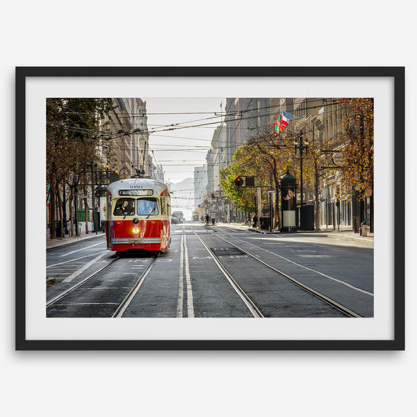 Fine art photograph of a cable car on Market Street in San Francisco, during golden hour. The image shows SF architecture, people, and the interplay of light and shadow.