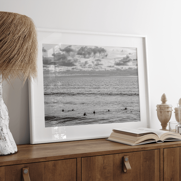 Black and white photo of surfers waiting in the water at sunset in Pismo Beach, California – fine art surf print.