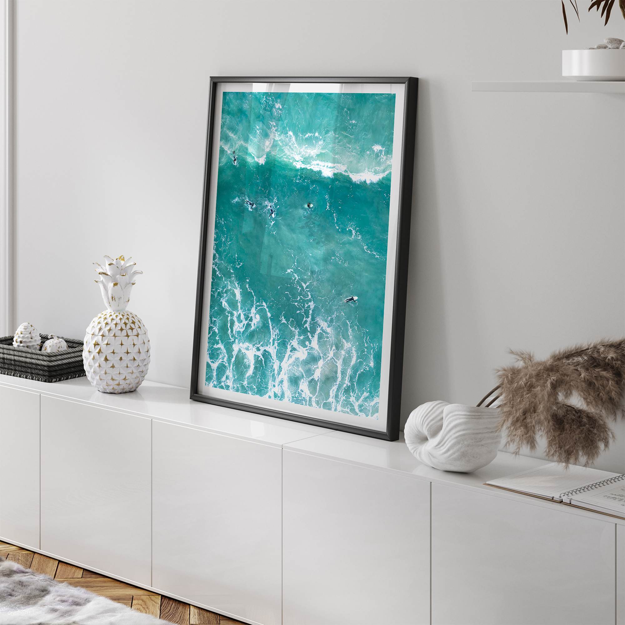 A fine art aerial ocean photography print showing surfers paddling for waves. Stunning blue wall art for home decor. 