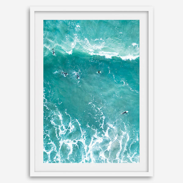 A fine art aerial ocean photography print showing surfers paddling for waves. Stunning blue wall art for home decor. 