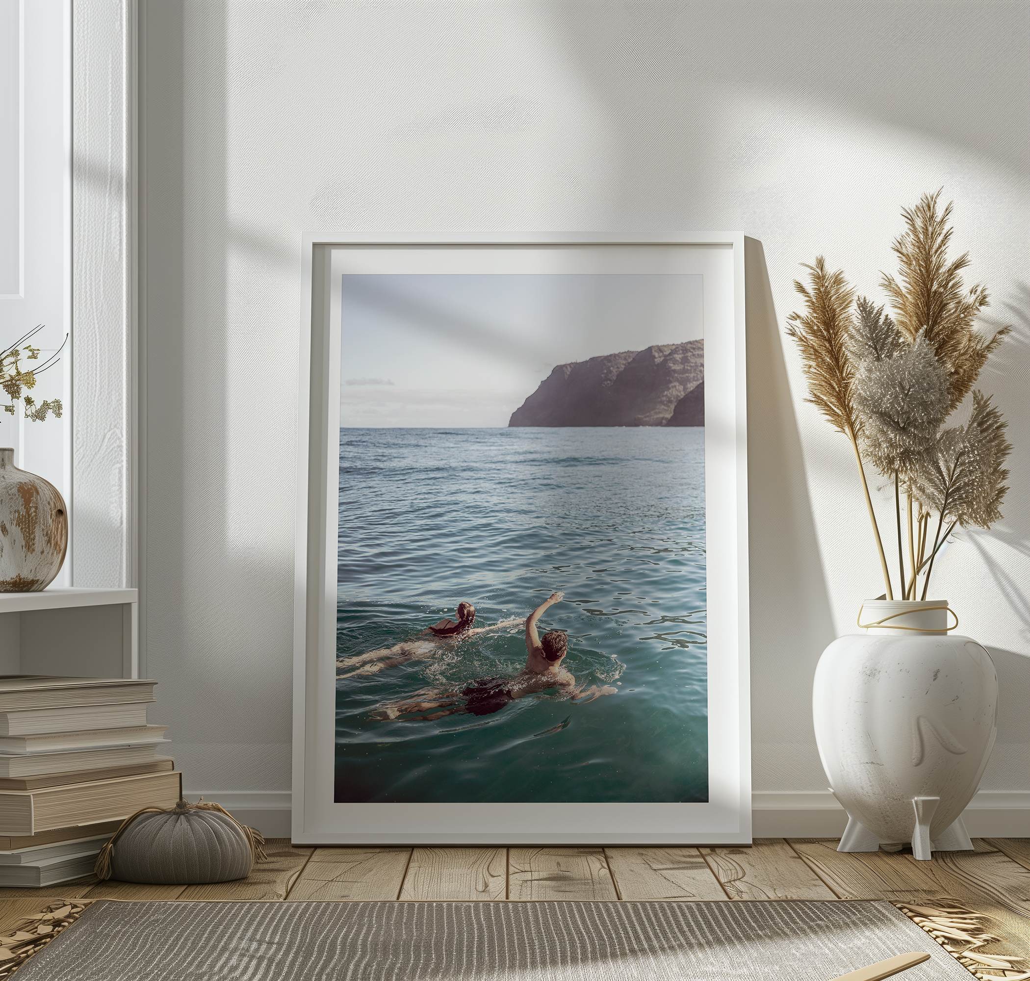 Summer wall art of a coastal Hawaiian landscape with figures swimming in deep blue ocean water.