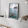 Summer wall art of a coastal Hawaiian landscape with figures swimming in deep blue ocean water.