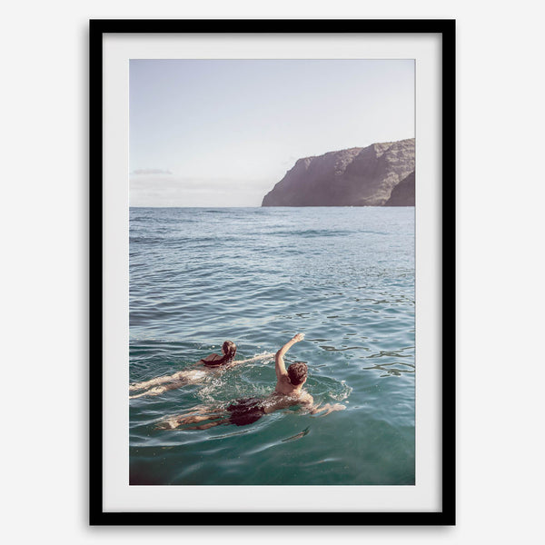 Summer wall art of a coastal Hawaiian landscape with figures swimming in deep blue ocean water.