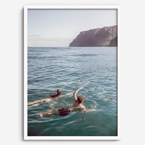 Summer wall art of a coastal Hawaiian landscape with figures swimming in deep blue ocean water.