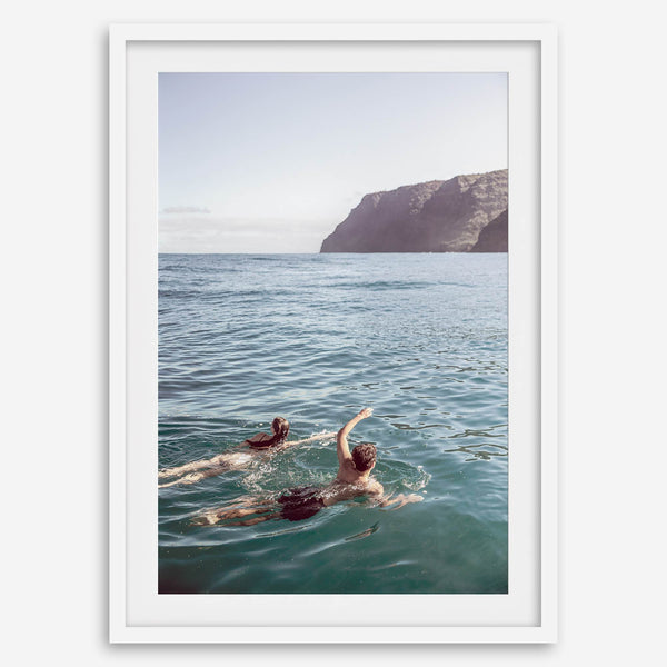 Summer wall art of a coastal Hawaiian landscape with figures swimming in deep blue ocean water.