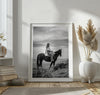 A black and white western rustic wall art - Cowgirl on horseback at sunset in desert landscape