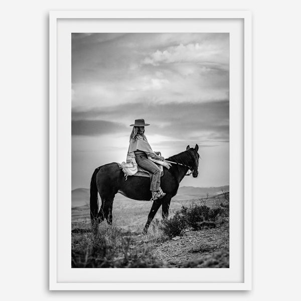 A black and white western rustic wall art - Cowgirl on horseback at sunset in desert landscape