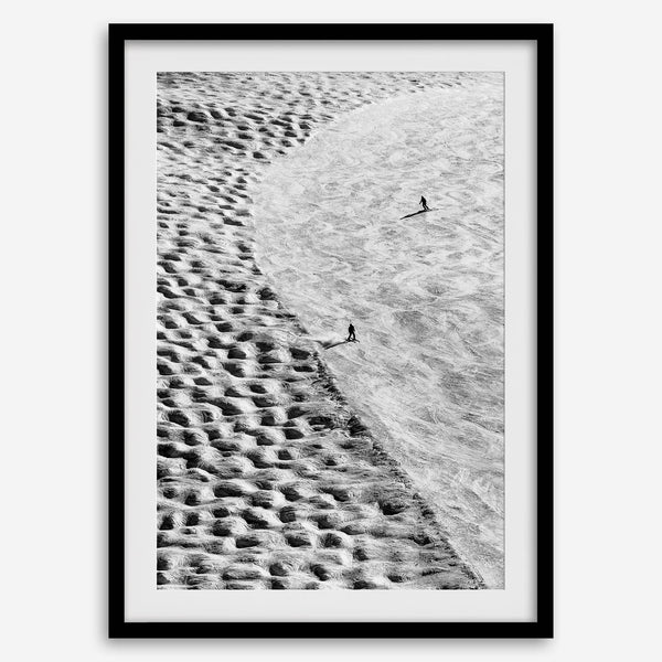 Aerial black and white ski art featuring two skiers on a textured mogul slope at Palisades Tahoe.
