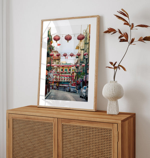 Chinatown Photography framed or unframed print showing red lanterns above a colorful San Francisco Chinatown street with shops and historic architecture.