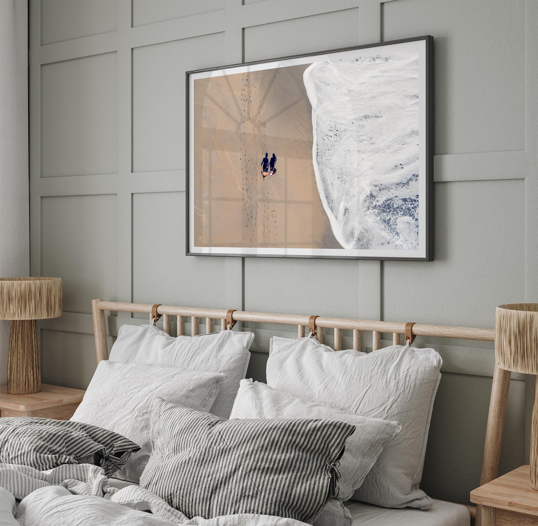 Aerial beach photograph of a couple beside Pacific Ocean waves in Capitola, California, styled as romantic coastal bedroom wall art.