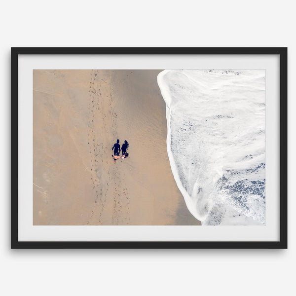 Aerial beach photograph of a couple beside Pacific Ocean waves in Capitola, California, styled as romantic coastal bedroom wall art.