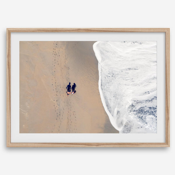Aerial beach photograph of a couple beside Pacific Ocean waves in Capitola, California, styled as romantic coastal bedroom wall art.