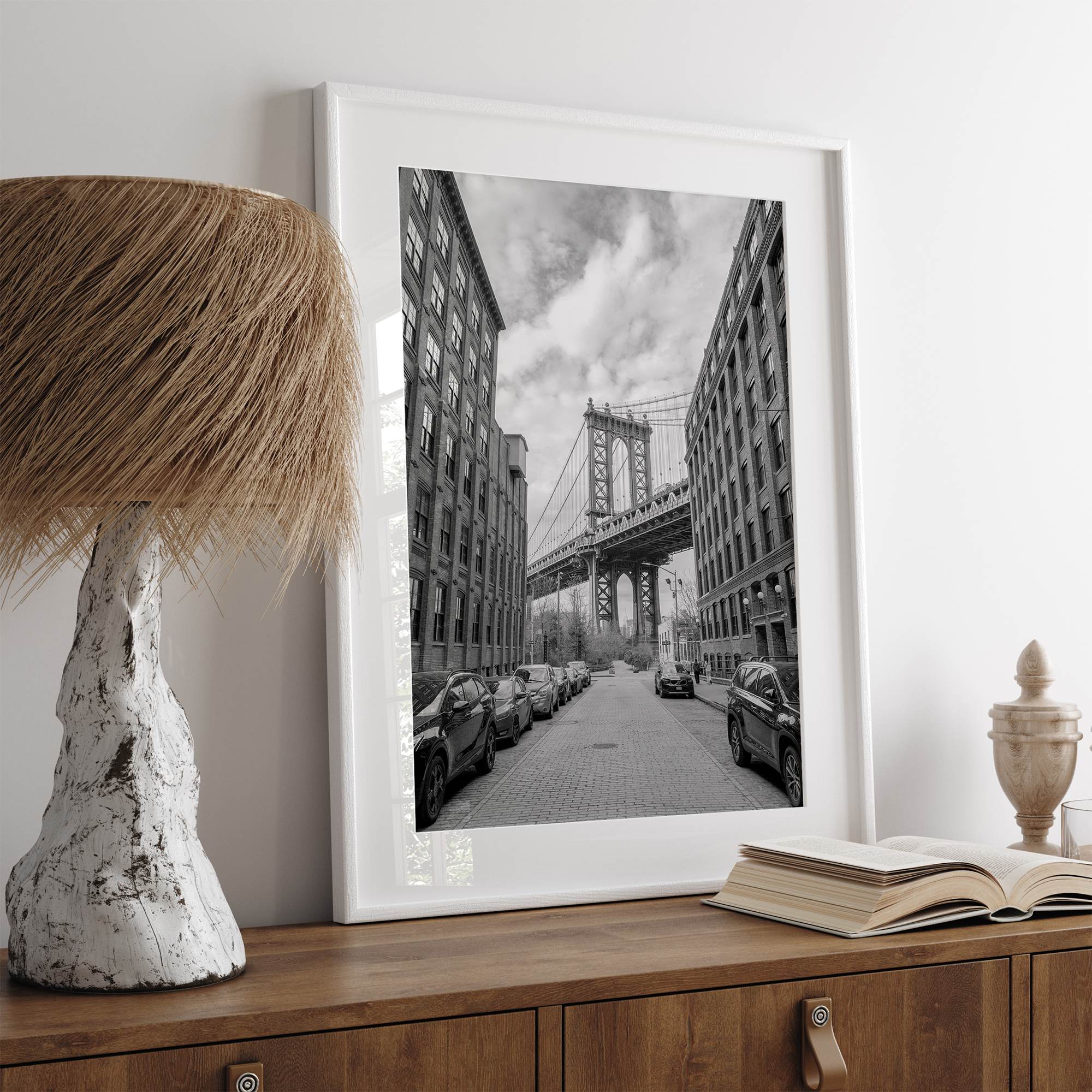 Framed Manhattan Bridge photography print in Dumbo Brooklyn with cobblestone street and monochrome architecture
